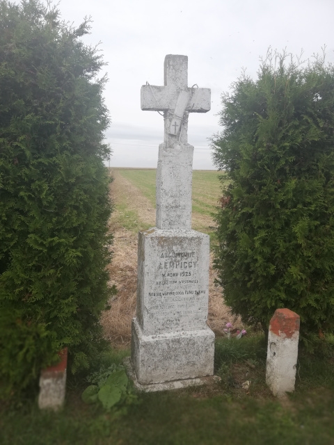 Krzyż murowany znajduję się przy drodze powiatowej Nr 0734T po prawej stronie w kierunku ujęcia wodnego widoczny napis: ”AUGUSTOWIE ŁEMPICCY W ROKU 1925 KRZYŻ TEN WYSTAWILI KTO SIĘ W OPIEKĘ ODDA PANU SWEMU”