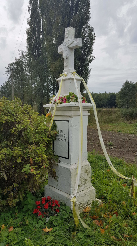 Krzyż murowany na postumencie po lewej stronie drogi powiatowej Nr 0728T w stronę drogi wojewódzkiej 755 z napisem 