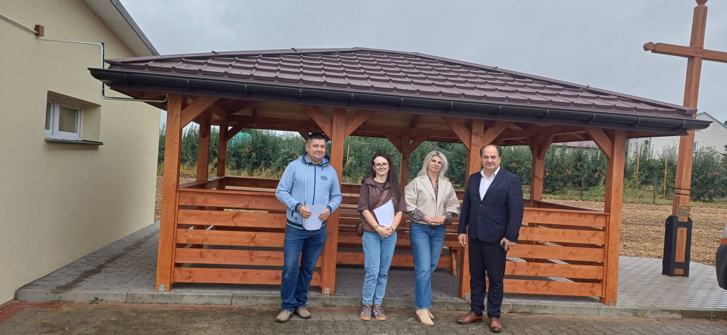 Od lewej wykonawca altany, pracownik Urzędu Gminy, Sołtys Orłowin oraz Wójt Gminy na tle drewnianej altany