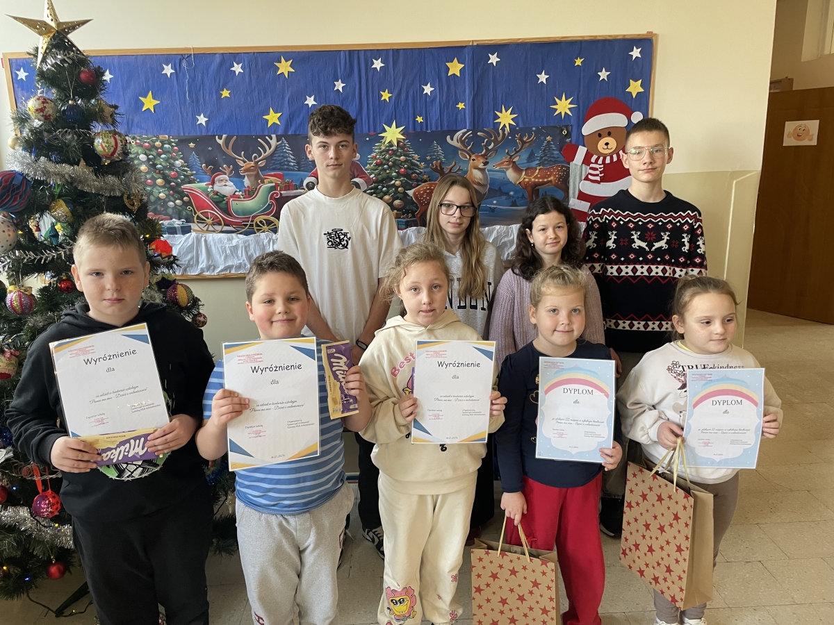 Uczniowie klas I-III biorący udział w konkursie wraz z Samorządem Uczniowskim. Z tyłu ścianka dekoracyjna